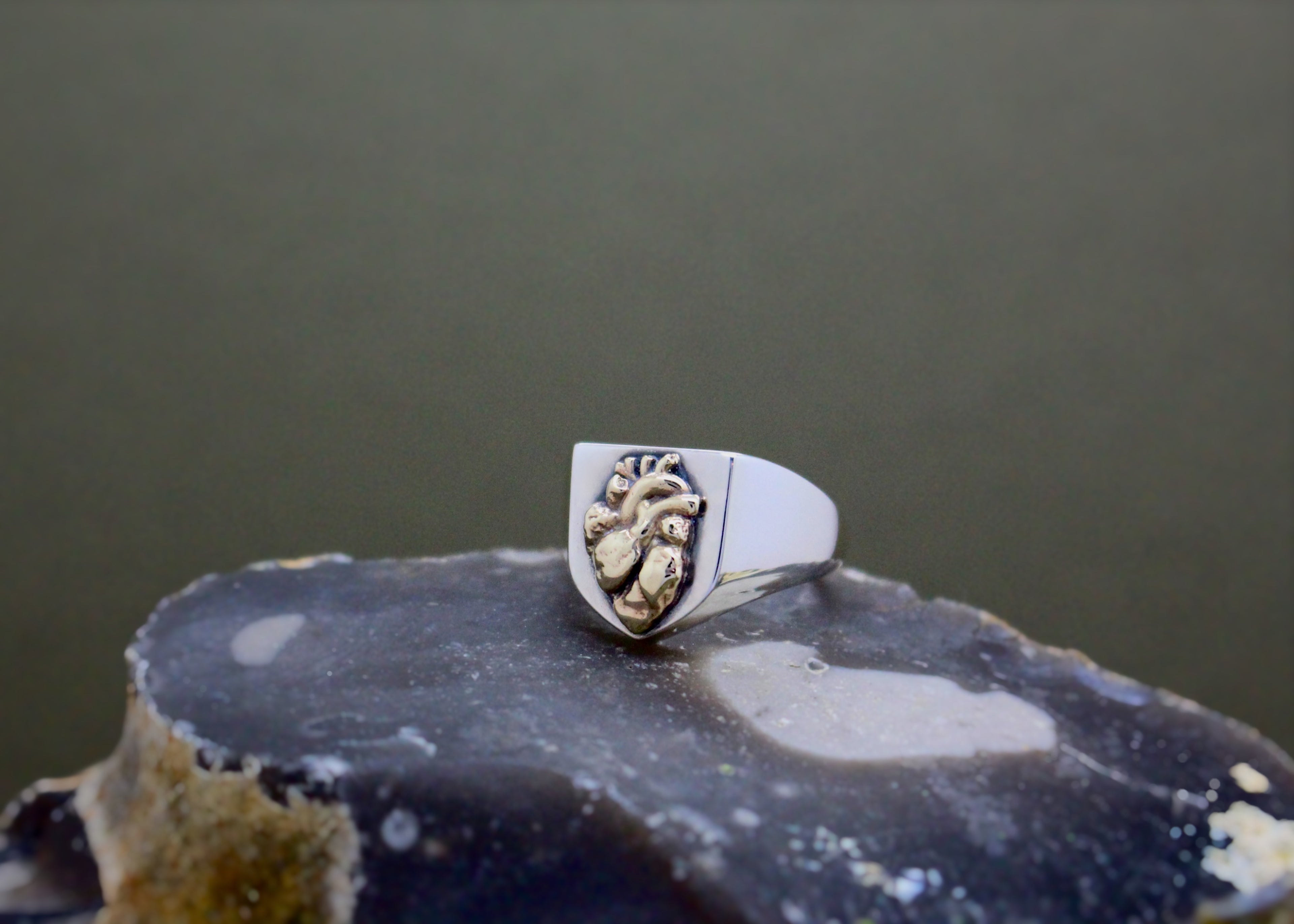 Silver shield wedding signet ring with yellow gold anatomical heart. Customised with Roman numeral engraving inside the band